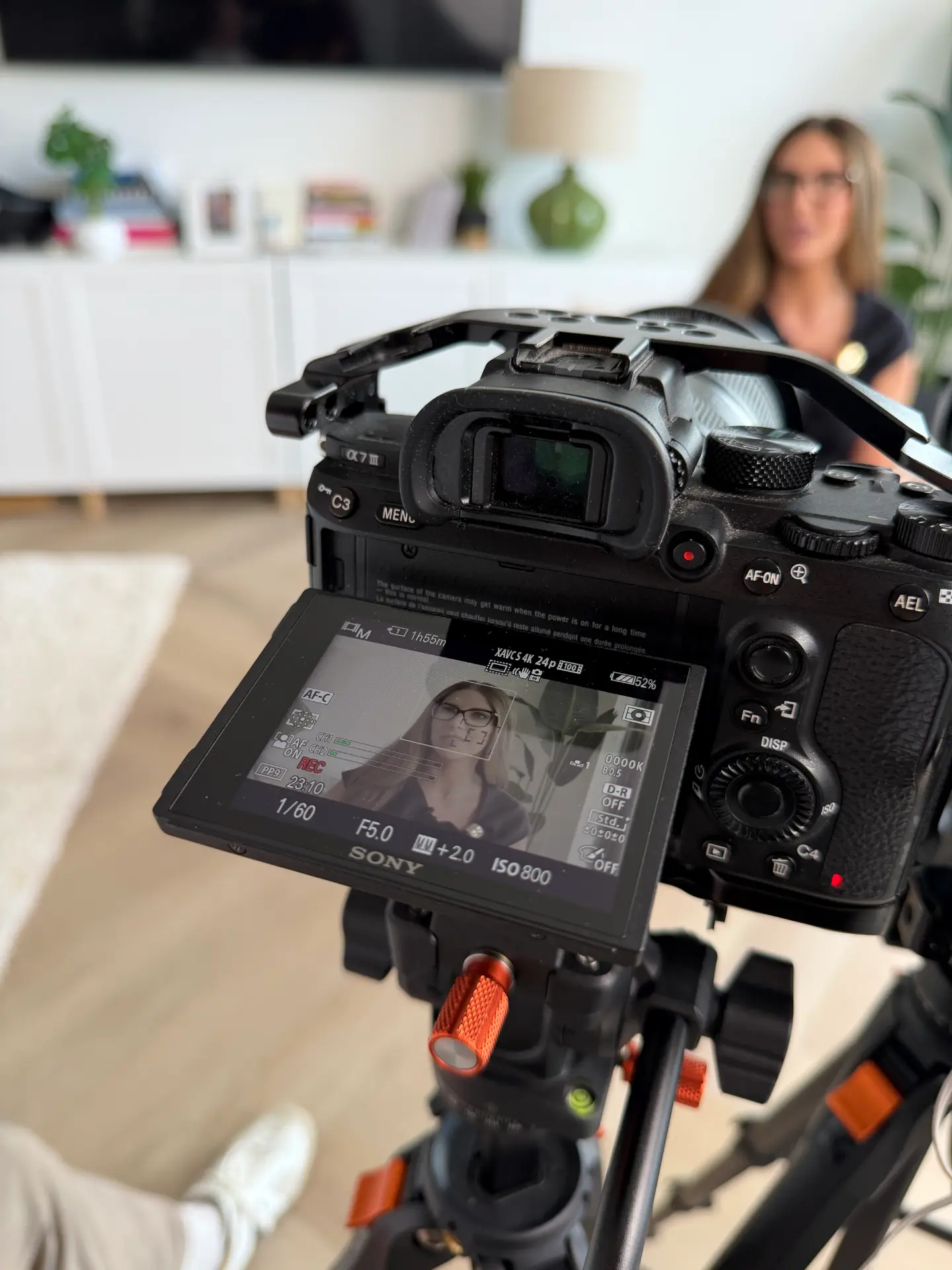 Camera on a tripod filming a subject during a content shoot