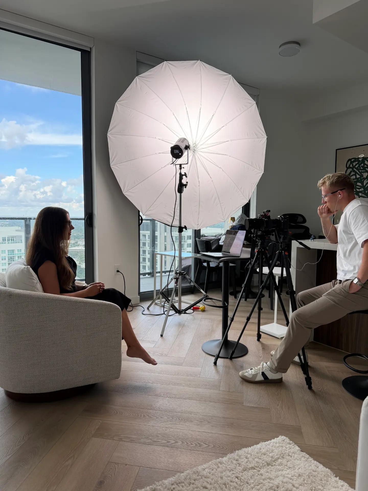 Interview shoot in a high-rise apartment with umbrella lighting and camera setup